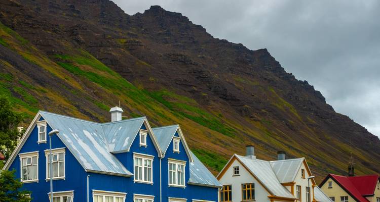 Maisons colorées avec un arrière-plan de montagne rocheuse.
