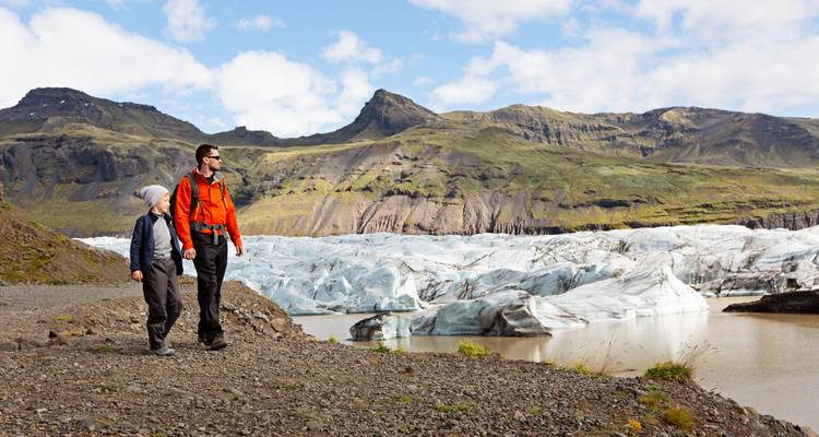 Deux personnes faisant de la randonnée près d'un glacier.
