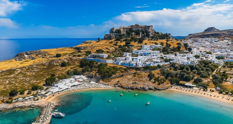 Scenic view of Lindos with a castle and beach.