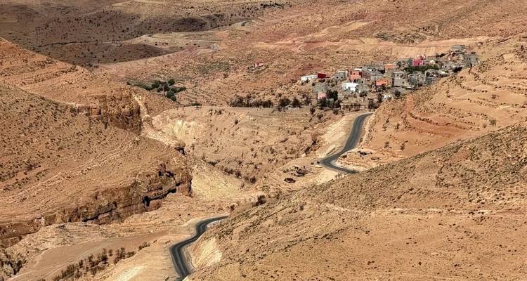 Klein dorp in dor landschap met kronkelende weg.