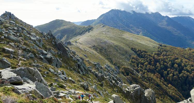 Sentier de randonnée avec des personnes marchant le long d'une crête montagneuse.