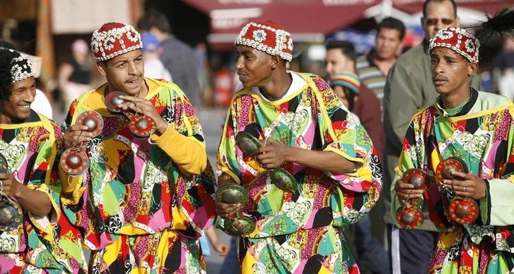 Groupe d'hommes en tenue traditionnelle colorée jouant des instruments.