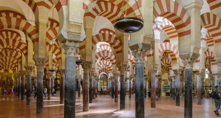 Interior of a mosque with red and white striped arches.
