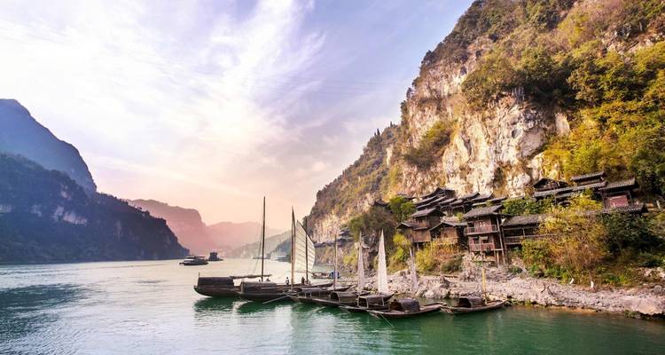 Vista panorámica del río Yangtze con barcos tradicionales al atardecer.