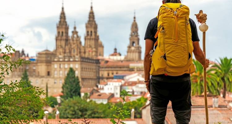 Peregrino con bastón mirando la Catedral de Santiago de Compostela.