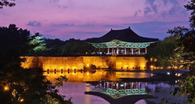 Un magnifique bâtiment historique illuminé avec son reflet dans l'eau au crépuscule.