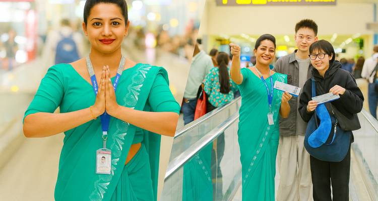 Gruppe von Menschen an einem Flughafen mit einem lächelnden Fluglinien-Mitarbeiter.