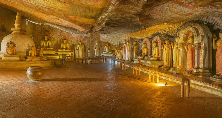 Inneres des Dambulla-Höhlentempels mit Statuen entlang der Wände aufgereiht.