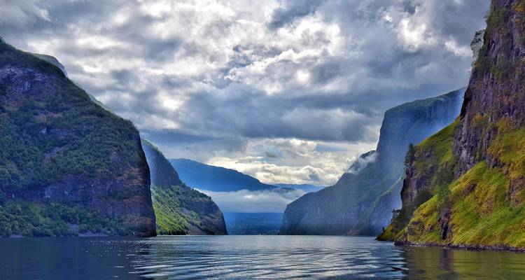 Fjord profond aux falaises escarpées et au ciel nuageux.