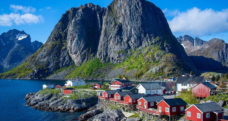 Village côtier pittoresque avec des maisons rouges et des falaises escarpées.
