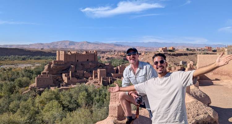 Deux personnes posant avec Ait Benhaddou en arrière-plan.