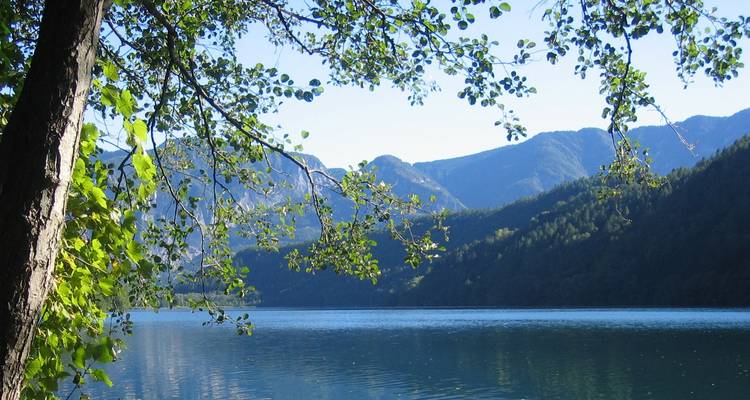 Lac avec des montagnes et des arbres en arrière-plan.