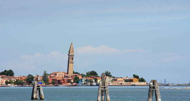 Vue d'une ville côtière avec une tour penchée.