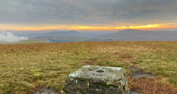 Vista desde la colina al atardecer con páramo extenso.