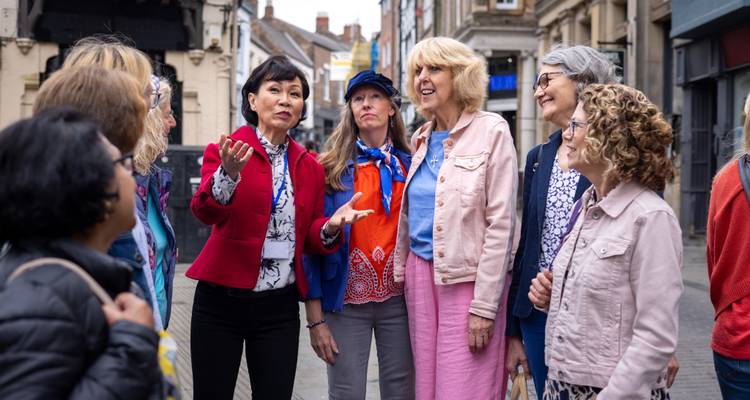 Groupe de femmes debout qui parlent ensemble dans une rue de la ville.