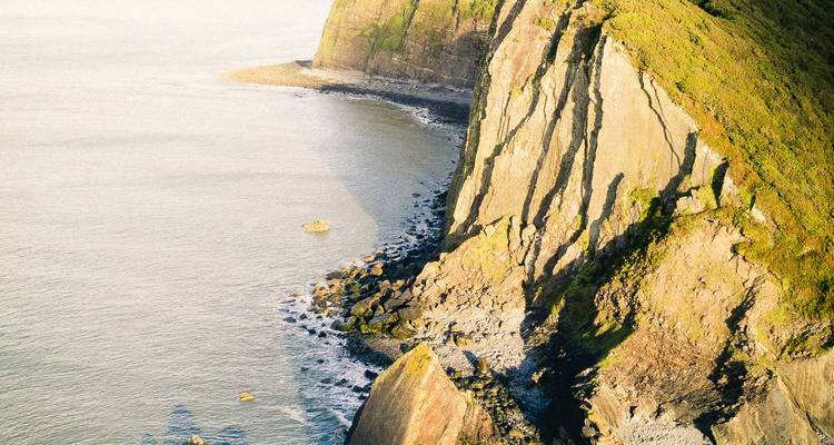 Falaise surplombant l'océan avec des ombres dramatiques.