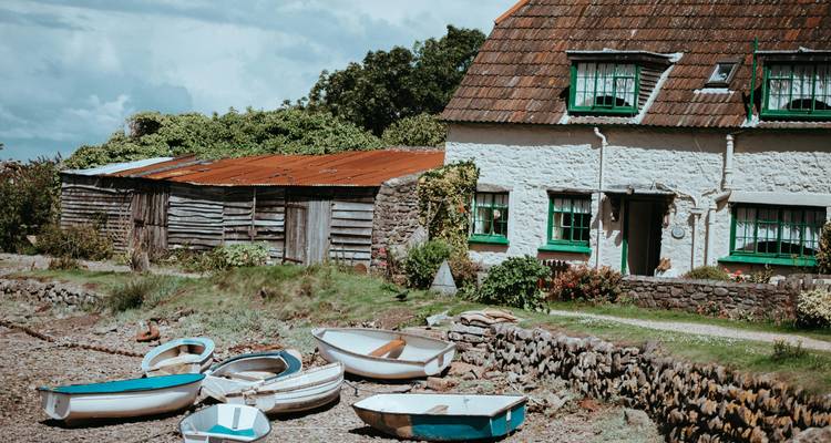 Cottage traditionnel avec des bateaux sur le sol dans un cadre rustique.