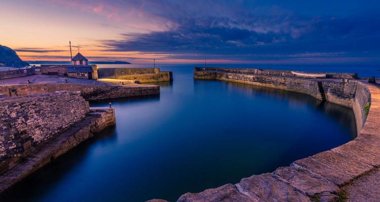 Port de Charlestown au crépuscule avec une eau calme et une atmosphère sereine.