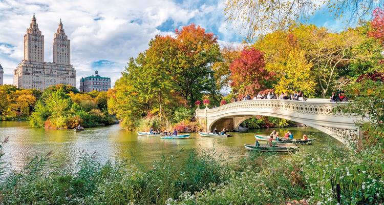 Central Park im Herbst mit einer malerischen Brücke und Wolkenkratzern.
