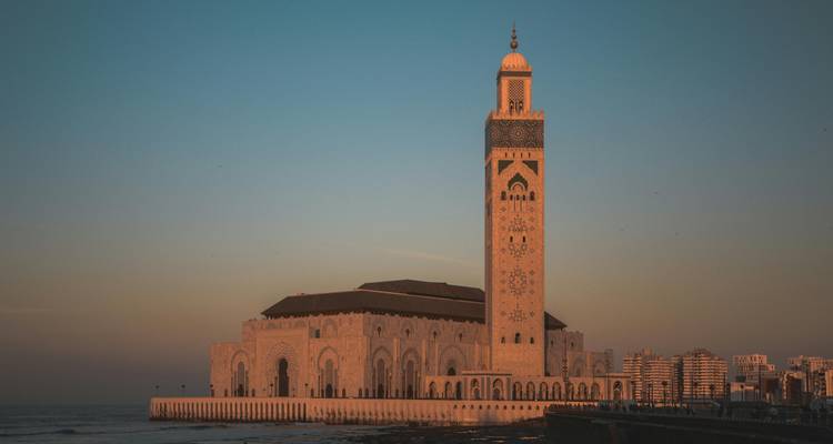 Mezquita Hassan II al atardecer con el océano a la vista.