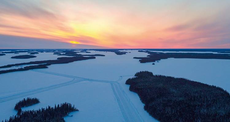 Coucher de soleil sur un vaste paysage gelé.