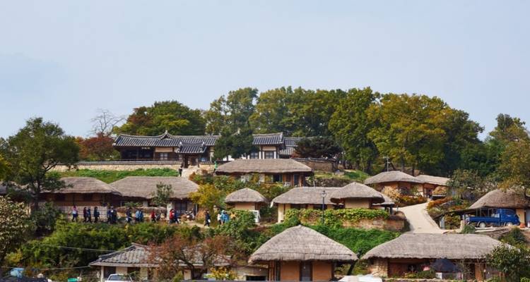Une scène de village avec des maisons coréennes traditionnelles et des toits de chaume.