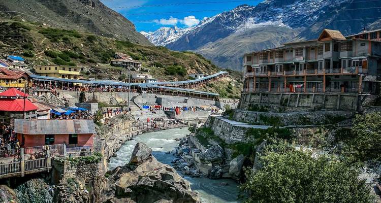 Vue panoramique d'une région montagneuse avec une rivière et des bâtiments.