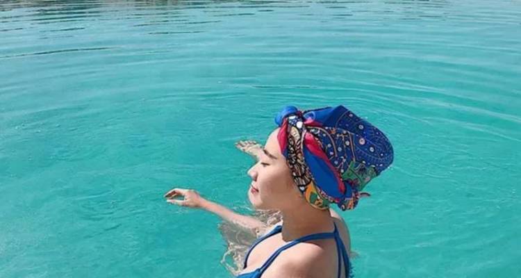 Personne avec un foulard coloré profitant de flotter dans une eau claire.