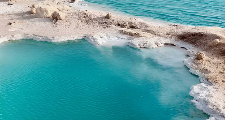 Eaux turquoise avec formations de sel dans un cadre désertique.