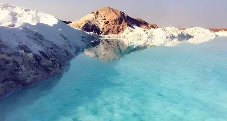 Eau turquoise reflétant des formations de sel blanc.