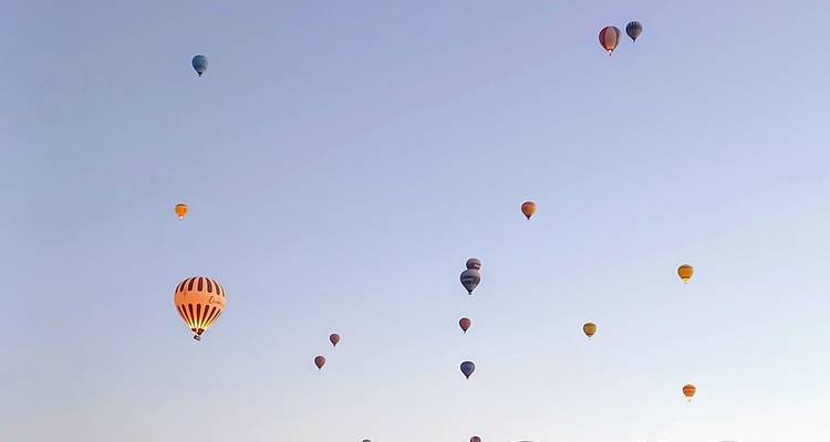 Heteluchtballonnen verspreid in de lucht boven Cappadocië.