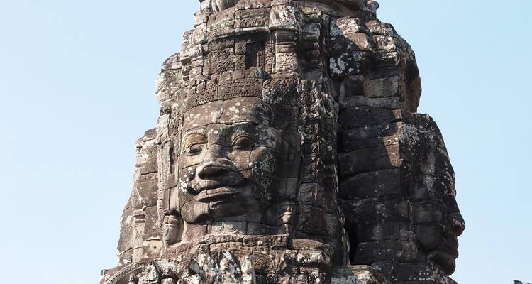 Primer plano de un rostro de piedra en una torre de templo antigua.