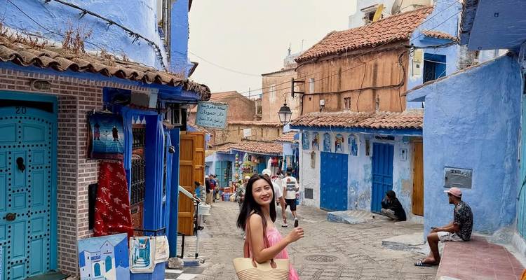 Scène de rue colorée avec des gens qui marchent dans une ville marocaine.