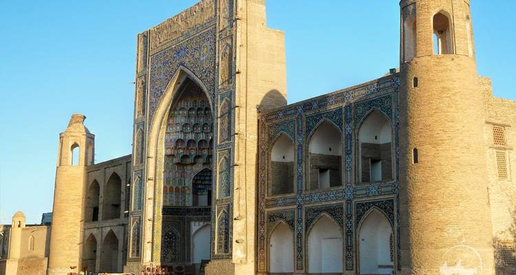 Un grand bâtiment historique avec un carrelage complexe et des arcs ornés.