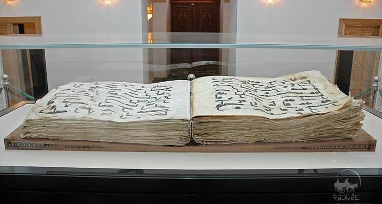 Large ancient book with intricate script on display.