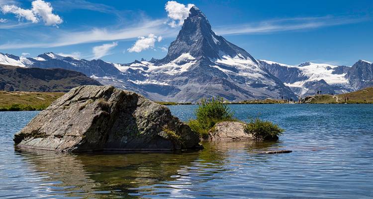 Iconic mountain peak reflected in a calm lake under a clear sky.