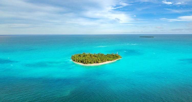 Een luchtfoto van een klein eiland omringd door turquoise zee.