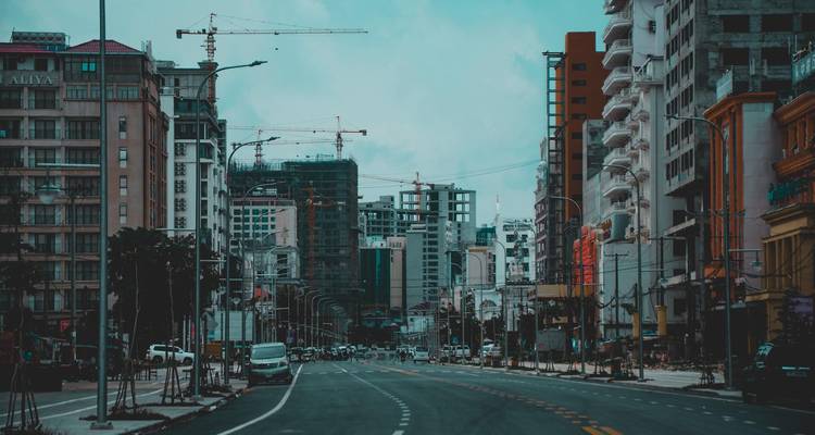 City street with modern buildings and construction cranes.