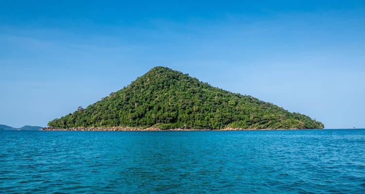 Small green island surrounded by blue ocean.