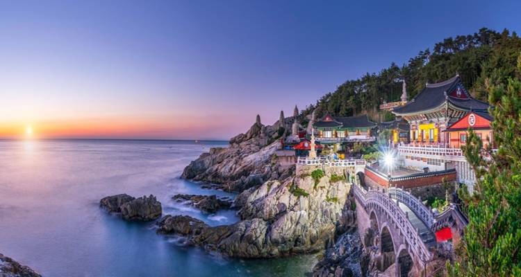A stunning seaside temple complex with a sunset view.