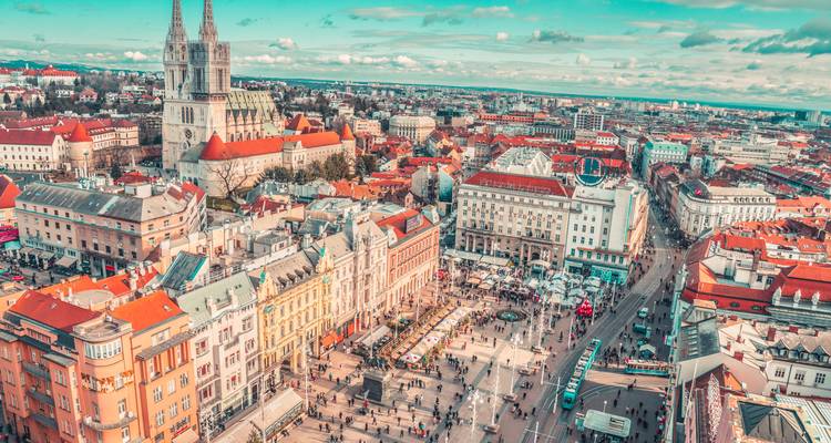 Vue urbaine avec une cathédrale et une place centrale.
