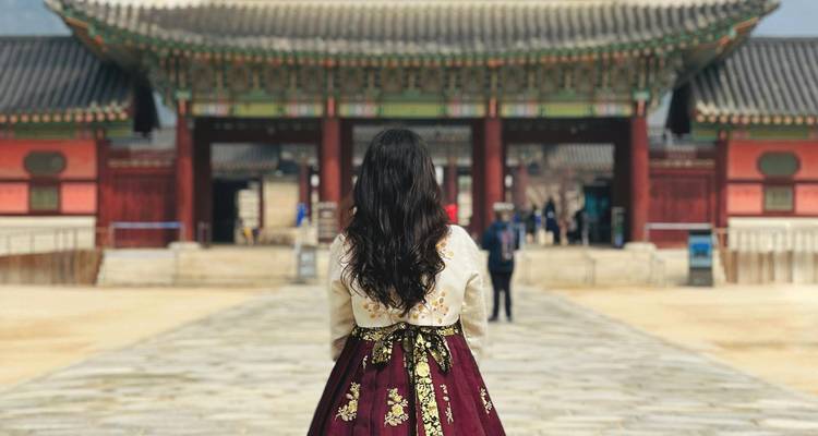 Une personne portant des vêtements traditionnels se tenant à l'entrée d'un palais.