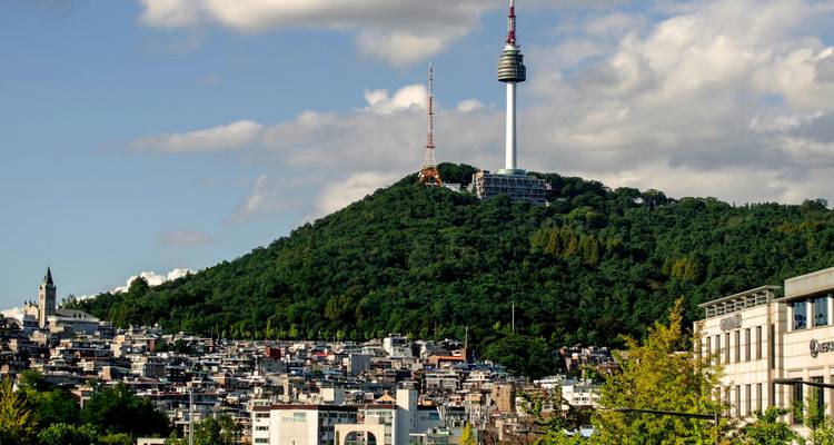 Vue panoramique d'une ville avec une tour proéminente sur une colline.