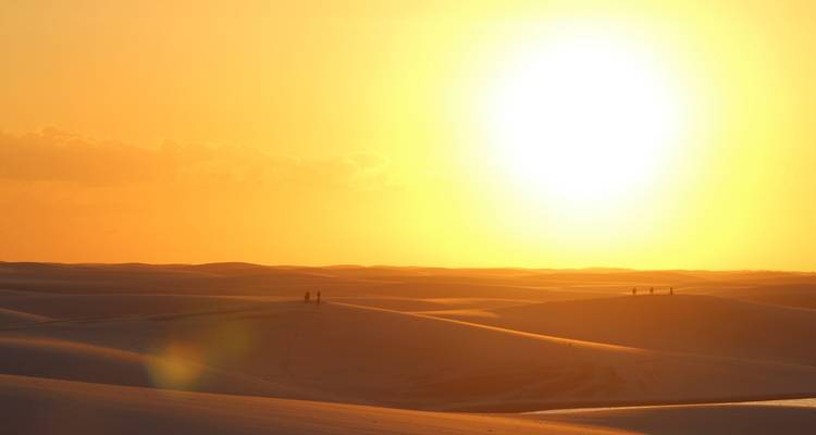 Coucher de soleil sur les dunes de sable créant des couleurs dramatiques.