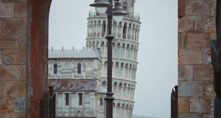 Tour penchée de Pise encadrée entre des arches.
