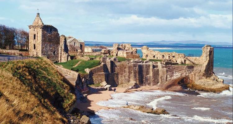 Ruines historiques au bord de la mer sous un ciel bleu éclatant.