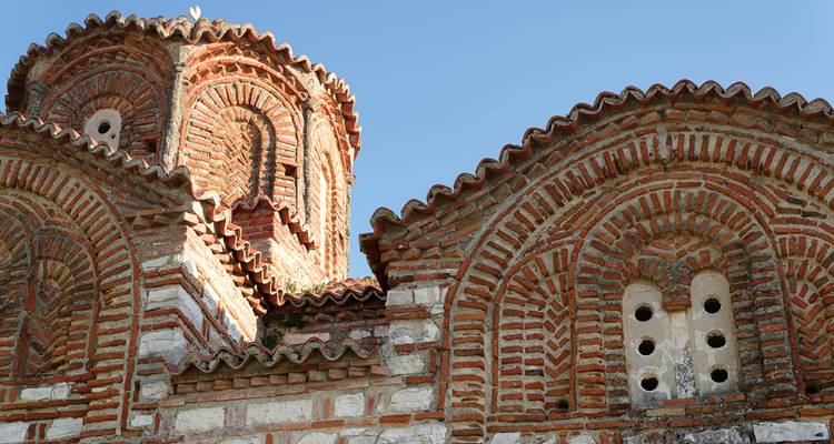Gros plan d'un bâtiment historique en brique et pierre au design complexe.
