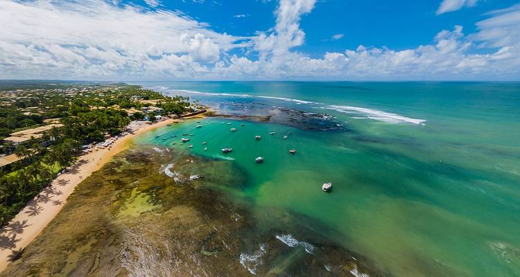 Aerial view of a coastline with turquoise ocean and white sandy beach.
