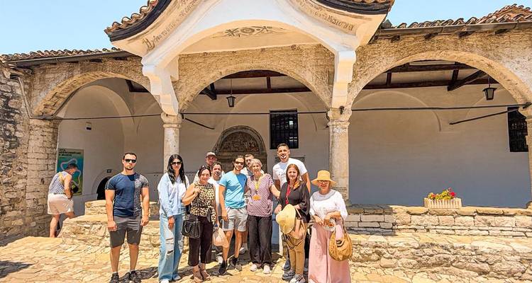 Los turistas se reunieron frente a una mezquita histórica con una gran entrada.