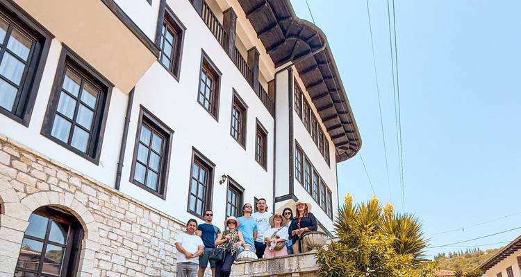 Grupo posando frente a un edificio tradicional con balcón.